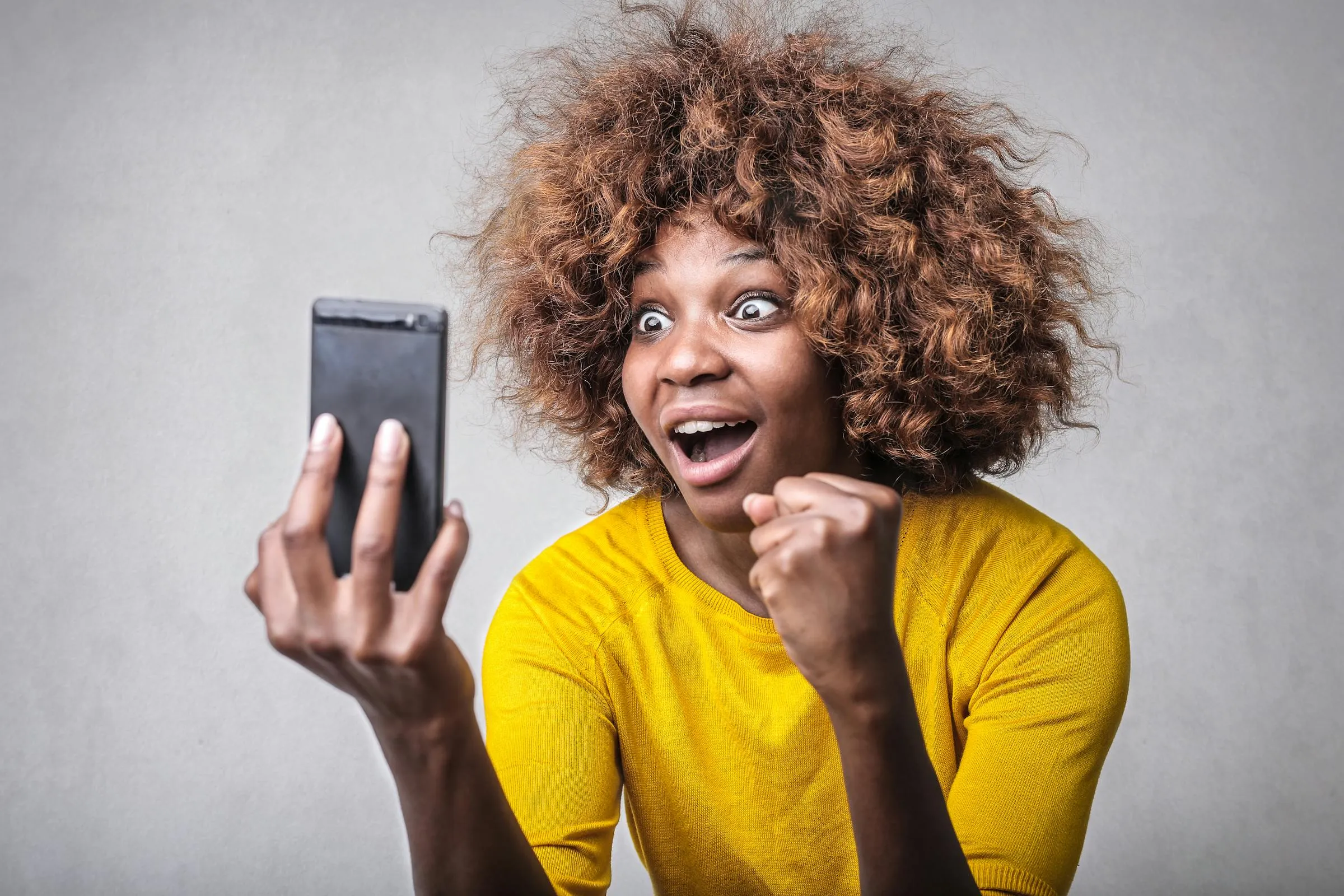 Woman excited looking at a reward notification on her phone